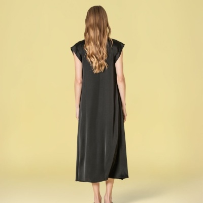 Vestido midi preto sem mangas visto de costas em fundo amarelo