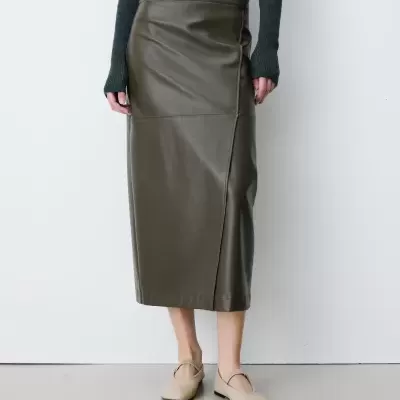 Saia midi verde-oliva de couro sintético com costuras, suéter cinza escuro e sapatos bege, fundo branco.
