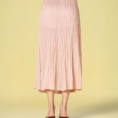 Saia rosa claro enrugada vista de costas com sapatos pretos de salto