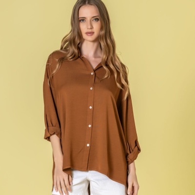 Camisa castanha de manga comprida com botões e calções brancos em fundo amarelo