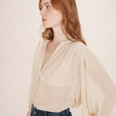 Camisa feminina transparente beige com mangas bufantes e calças de ganga azul escuro