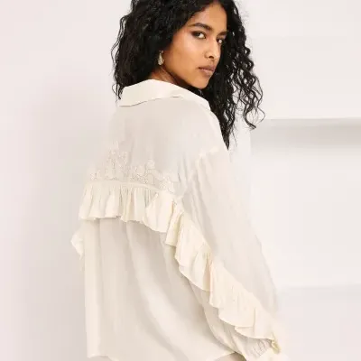 Blusa creme com bordado floral e folhos nas costas e mangas