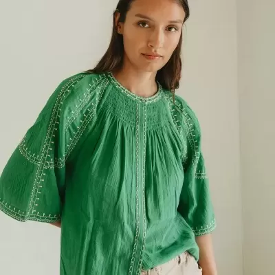 Blusa verde com bordados claros e calças claras com cinto de corda