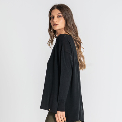 Mulher com camisola preta de manga comprida e saia verde oliva