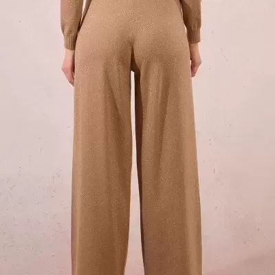 Calças largas castanhas brilhantes vistas de costas