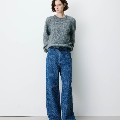 Mulher com camisola cinzenta e jeans azuis largos