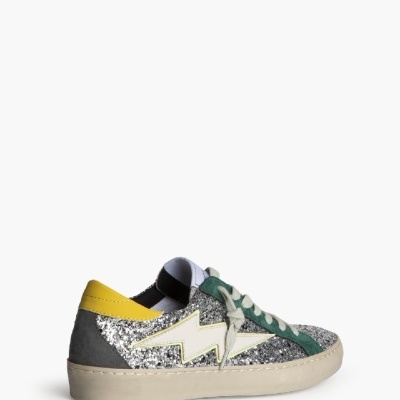 Tênis brilhante prateado com sola creme e detalhe amarelo e verde.