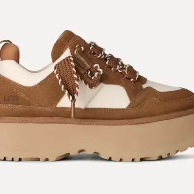 Ténis de plataforma castanhos e bege com sola grossa e atacadores entrelaçados.