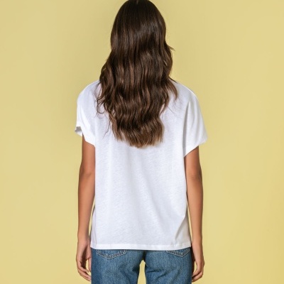 Pessoa de costas com t-shirt branca e calças de ganga azuis