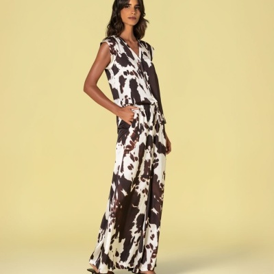 Conjunto feminino com padrão animal em tons castanhos e branco e sandálias pretas.