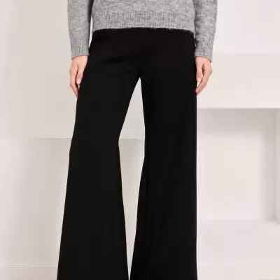 Calças pretas de corte largo com camisola cinzenta de malha com pedraria