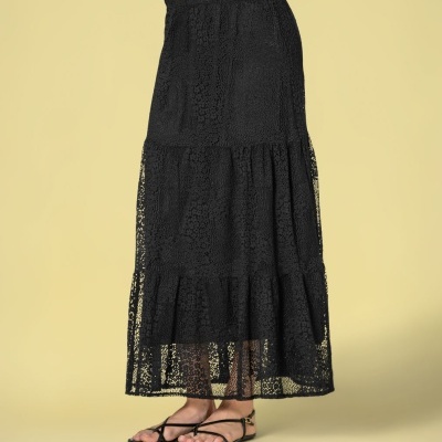 Saia preta longa de tecido rendado com três camadas e sandálias pretas