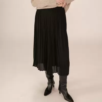 Saia midi preta plissada com botas pretas e camisola castanha clara