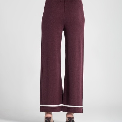 Calças largas bordô com riscas brancas na barra e sapatos de salto finos bordô