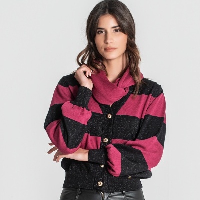 Mulher com casaco às riscas preto e rosa escuro e calças de couro pretas