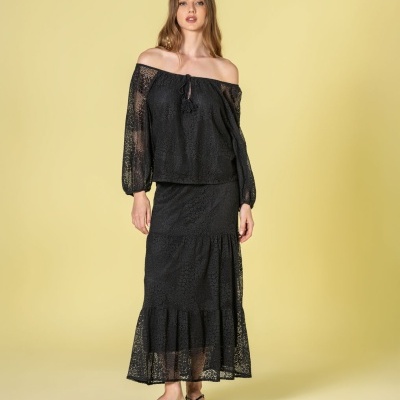 Conjunto feminino preto ombro a ombro com saia longa texturizada em fundo amarelo