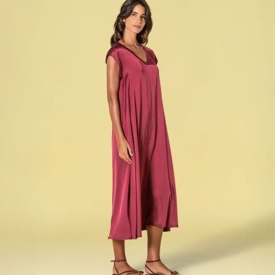 Vestido comprido cor de vinho com sandálias rasas em fundo amarelo