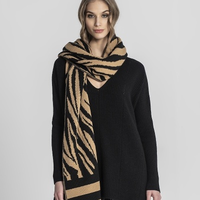 Mulher com cachecol de padrão animal print castanho e preto e camisola preta