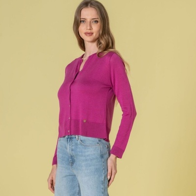 Mulher a usar camisola rosa de malha e jeans azuis