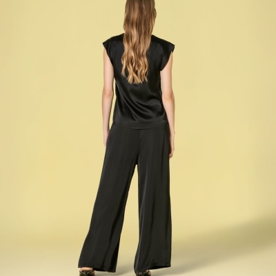 Conjunto feminino preto visto de costas com blusa sem mangas e calças largas