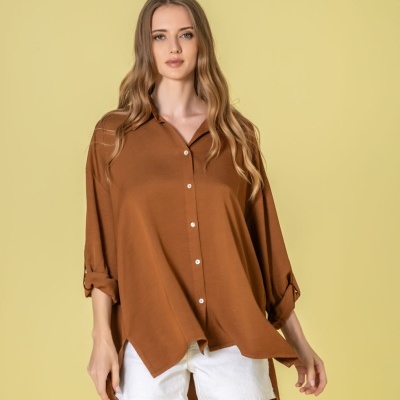 Blusa castanha com botões brancos e calções brancos em fundo amarelo