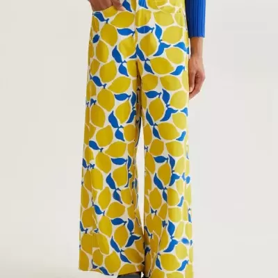 Calças estampadas com limões amarelos e folhas azuis e camisola azul de malha.