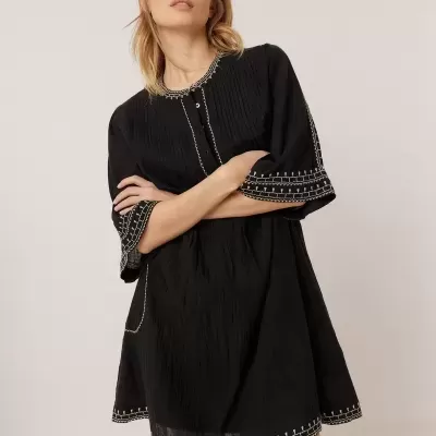 Vestido preto textura leve com costura branca nas mangas e bainha, botões no decote, modelo feminino