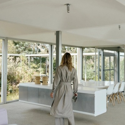 Interior moderno com mulher de pijama cinzento e grandes janelas