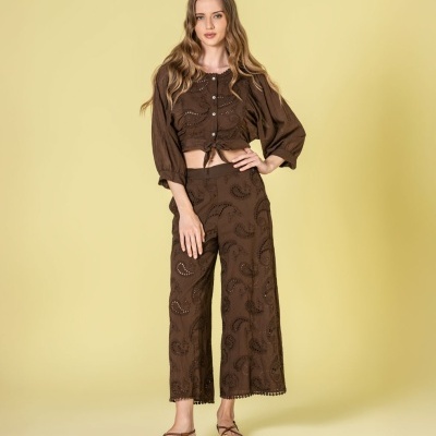 Conjunto castanho com padrão bordado em modelo com sandálias castanhas