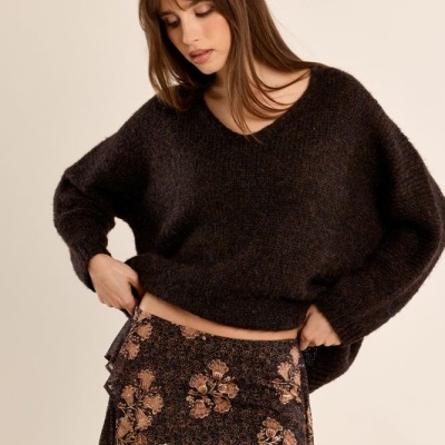 Camisola castanha escura de malha e saia preta com padrão floral em tons castanhos e bege