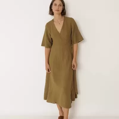 Mulher com vestido castanho midi de linho e sandálias castanhas