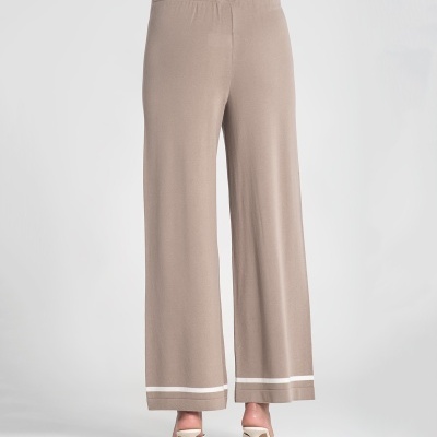 Calças castanho claro largas com detalhe branco na bainha e sapatos de salto brancos