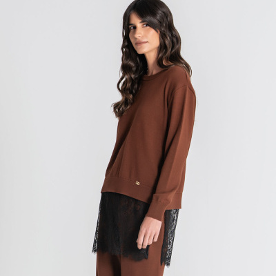Mulher a usar camisola castanha e saia ou vestido preto com renda