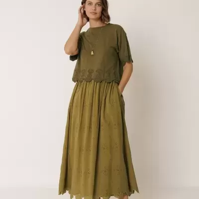 Blusa verde bordada e saia comprida verde com padrão recortado