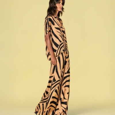 Conjunto de camisa e calças largas com padrão gráfico preto e bege.