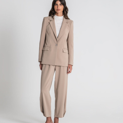 Conjunto feminino bege com blazer e calças largas, camisa branca e sapatos de salto