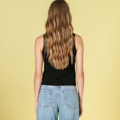 Pessoa de costas com top preto e calças de ganga azuis