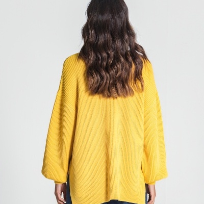 Mulher de costas com camisola amarela de malha e calças de ganga azuis