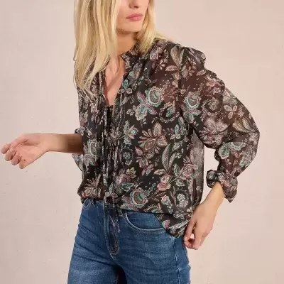Blusa transparente com padrão floral usado com jeans azul.
