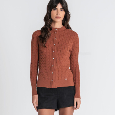Cardigan feminino castanho com botões e padrão torcido vestida com calções pretos.