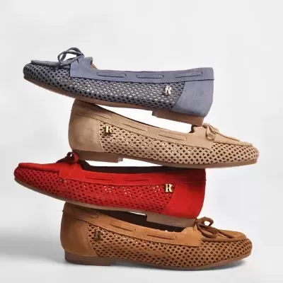Quatro pares de mocassins em azul, bege, vermelho e castanho empilhados, com textura perfurada e detalhes em laço e letra R dourada.