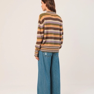 Mulher de costas com camisola às riscas e calças largas de ganga