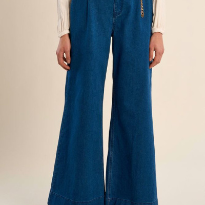 Calças largas de ganga azul escuro com cinto cadeia dourada e camisa creme