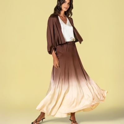 Mulher com conjunto castanho e saia longa gradiente de castanho para bege com blusa branca e sandálias pretas