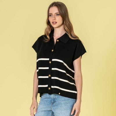 Camisola preta com riscas brancas e botões dourados, combinada com jeans claros