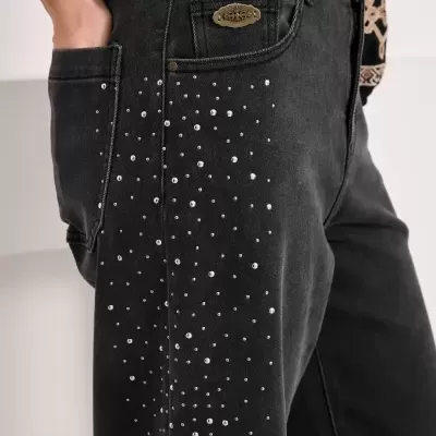 Calças de ganga pretas com tachas metálicas e placa com palavra NISIN no bolso