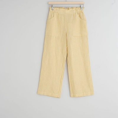 Calças xadrez amarelo e branco penduradas numa cabide