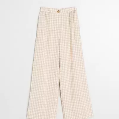 Calças largas bege com padrão xadrez branco sobre fundo branco