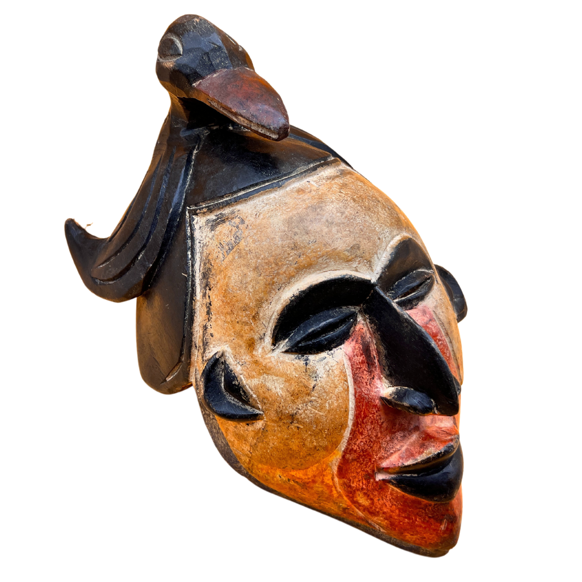 Máscara escultórica de madeira pintada com rosto estilizado e pássaro no topo