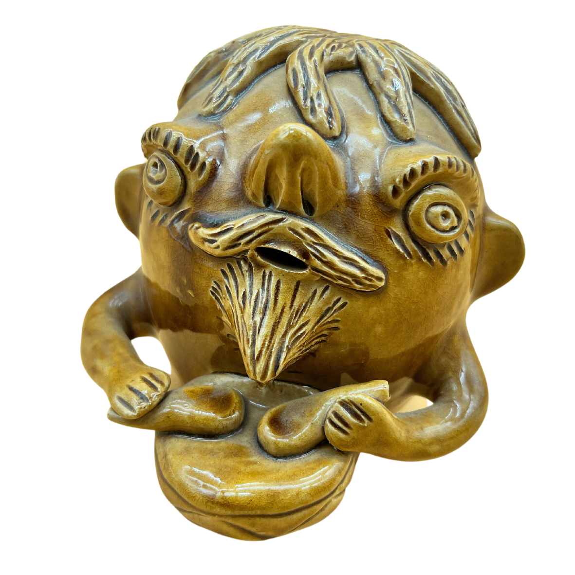 Máscara escultórica de cerâmica castanha e amarela com figura humana detalhada